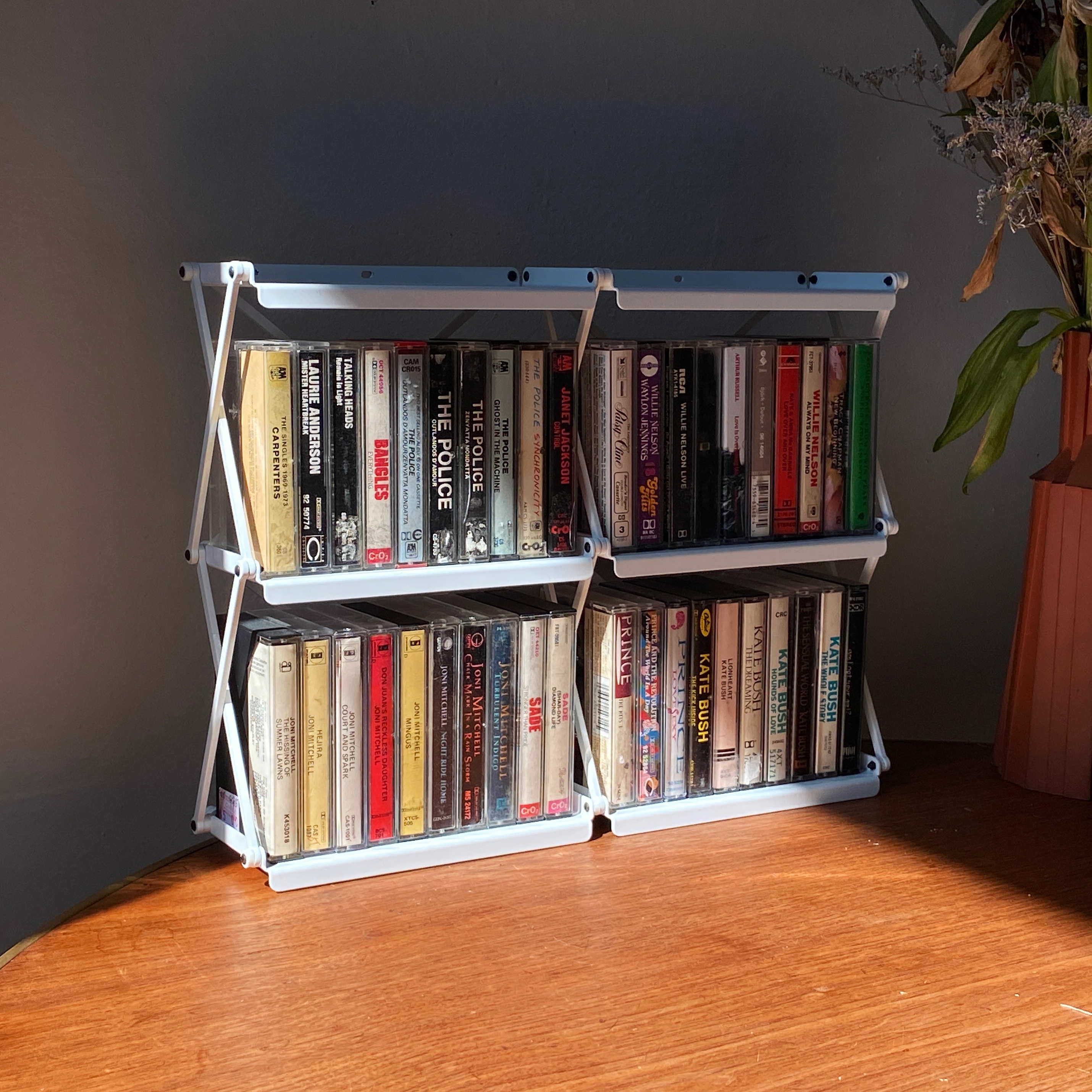 A 2x2 cassetteshelf mounted on a wall and fully loaded with cassette tapes